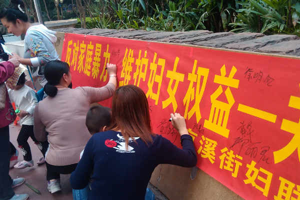 居民在活动横幅上进行反家暴签名