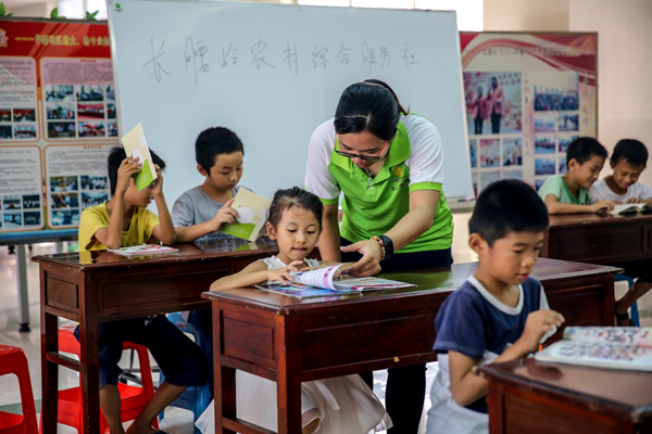 小朋友们在义工志愿者引导下学习 小朋友们在义工志愿者引导下学习